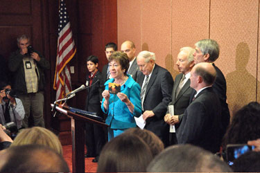 Sen. Susan Collins (R-Maine) shares a postcard she received from a servicemember at a Capitol Hill news conference.