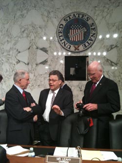 Sens. Jeff Sessions (left) and Al Franken (center) talk during a break Wednesday in the Senate Judiciary Committee hearings for Supreme Court nominee Elena Kagan, as Sen. Patrick Leahy reviews pictures of the hearing that he had taken earlier in the day.