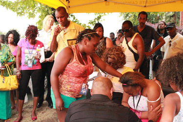 Lashai Mclean's mother weeps as gatherers comfort her