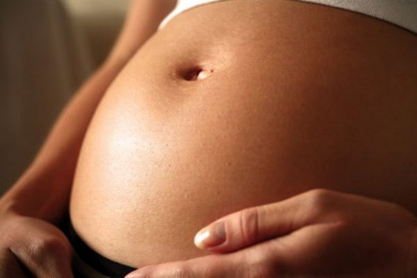 Photograph of abdomen of a pregnant woman (Credit: Canwest News Service, via Wikimedia Commons).