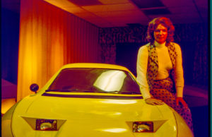 Elizabeth Carmichael sitting on yellow car